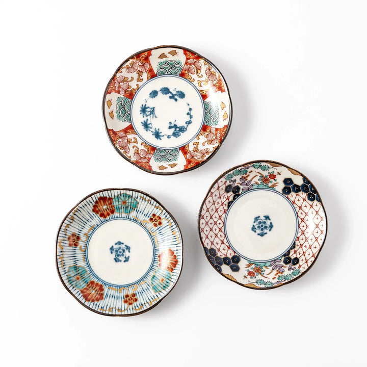 Set of three scalloped Japanese sauce dishes with red blue and gold floral patterns ideal for condiments.