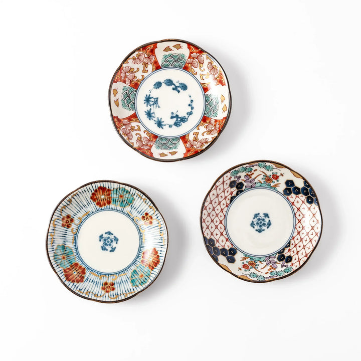 Three scalloped Japanese sauce dishes with red blue and gold floral patterns perfect for condiments or sides.