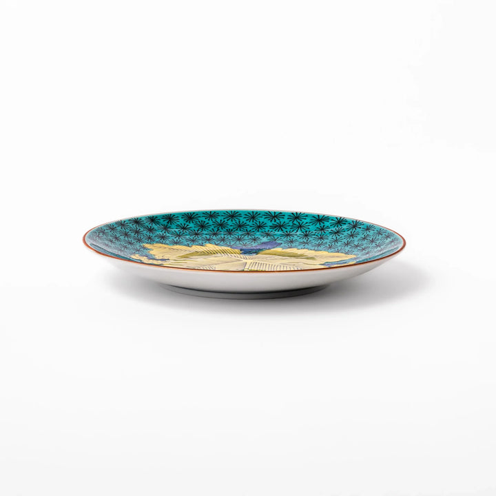 Round Kutani dessert plate with a bold golden leaf and grape motif on a turquoise background patterned with black starbursts.