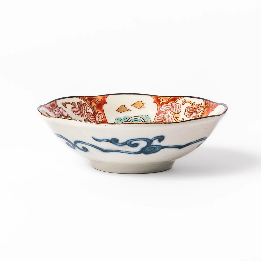 Scalloped Japanese dessert bowl with red green and gold patterns and blue floral center for elegant dining.
