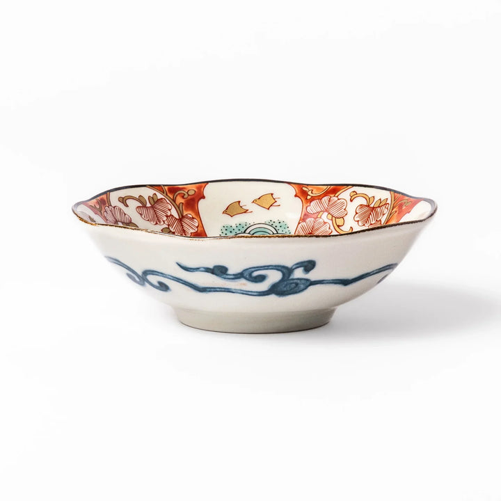 Scalloped Japanese dessert bowl with red green and gold patterns and blue floral center for elegant dining.