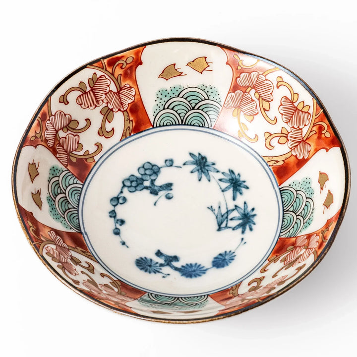 Scalloped Japanese dessert bowl with red green and gold patterns and blue floral center for elegant dining.