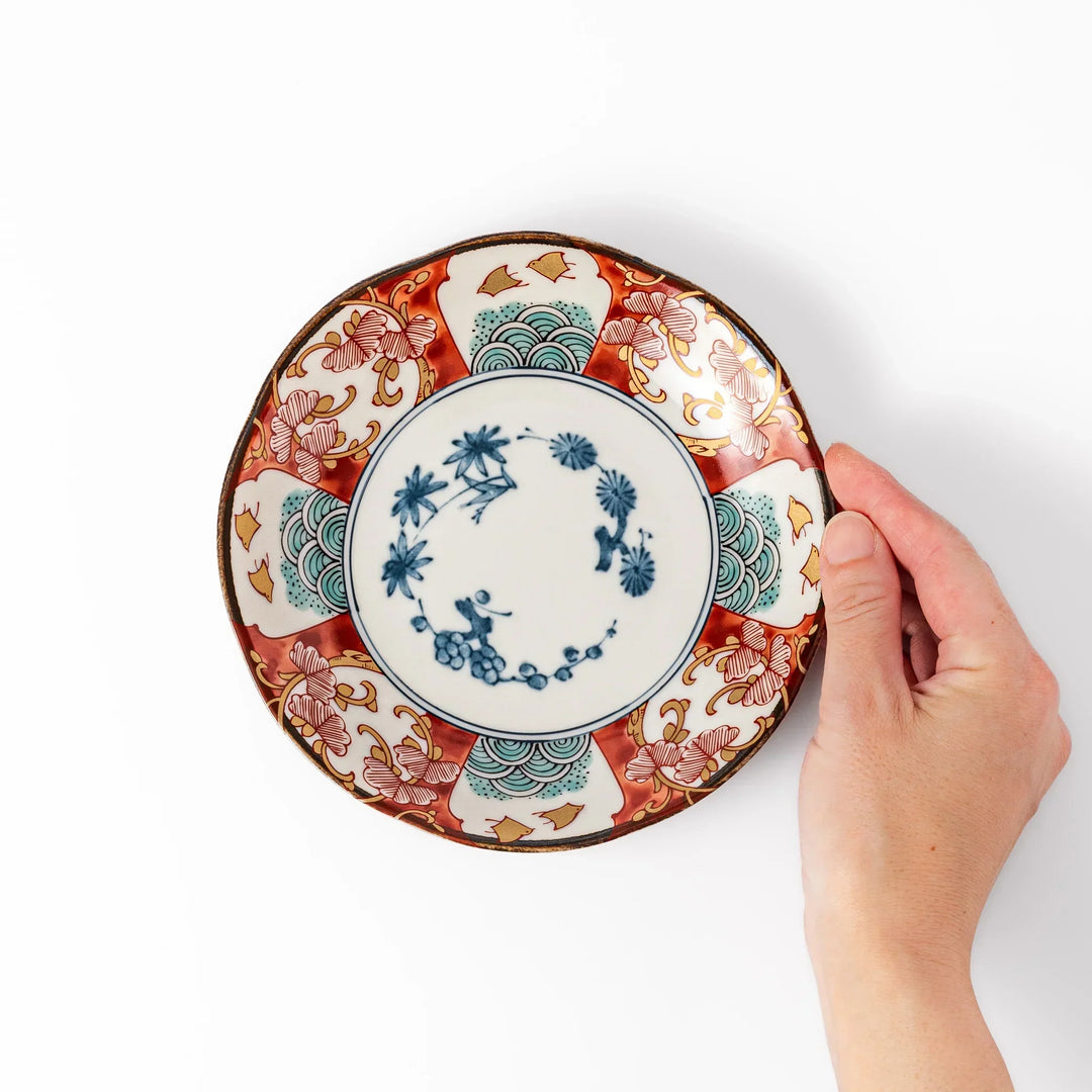 Elegant Japanese dessert plate with scalloped edge blue floral center and red gold and green patterns for refined dining.