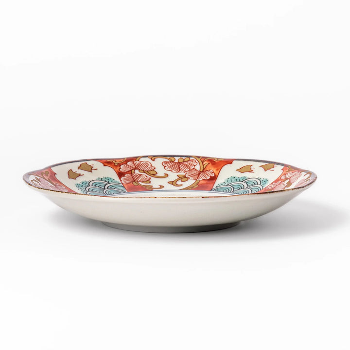 Elegant Japanese dessert plate with scalloped edge blue floral center and red gold and green patterns for refined dining.