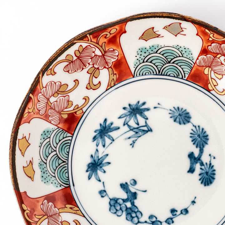 Elegant Japanese dessert plate with scalloped edge blue floral center and red gold and green patterns for refined dining.