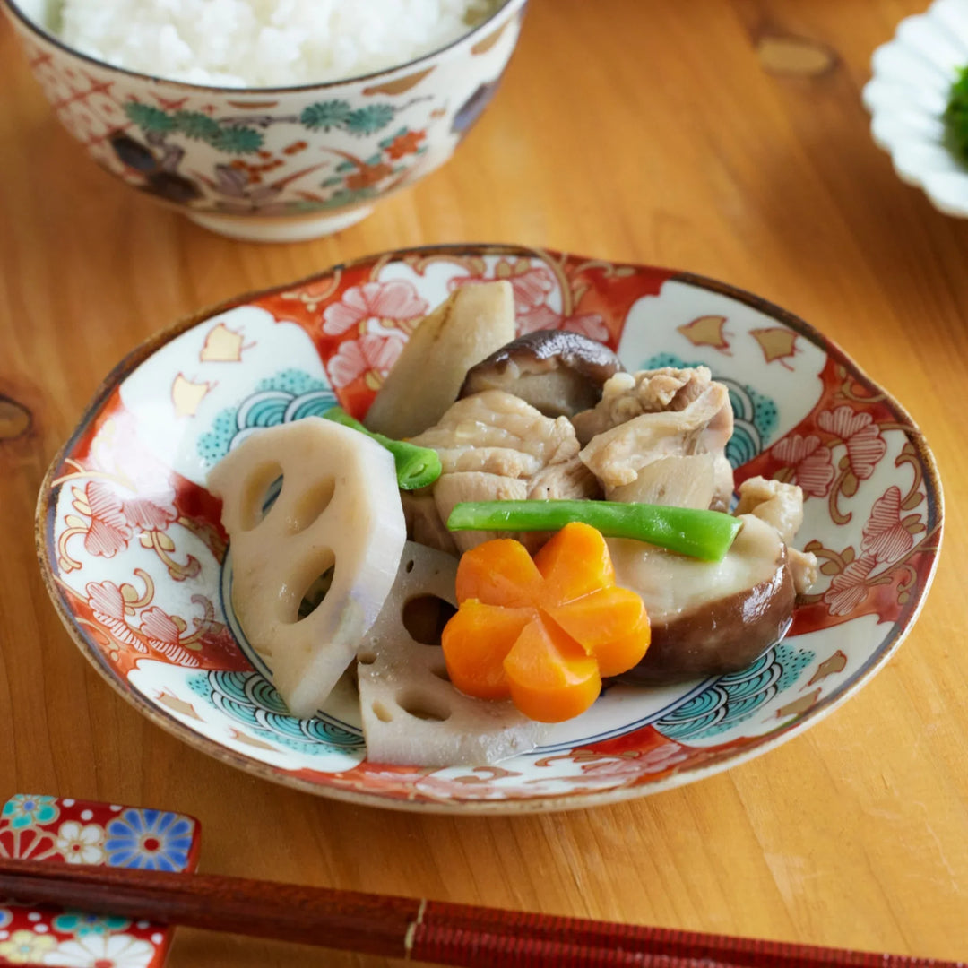 Japanese porcelain plate with red and gold patterns, serving simmered chicken, lotus root, shiitake, carrot, and green beans.