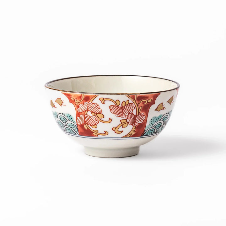 Traditional Japanese rice bowl with red green and gold motifs featuring waves florals and birds for refined meals.