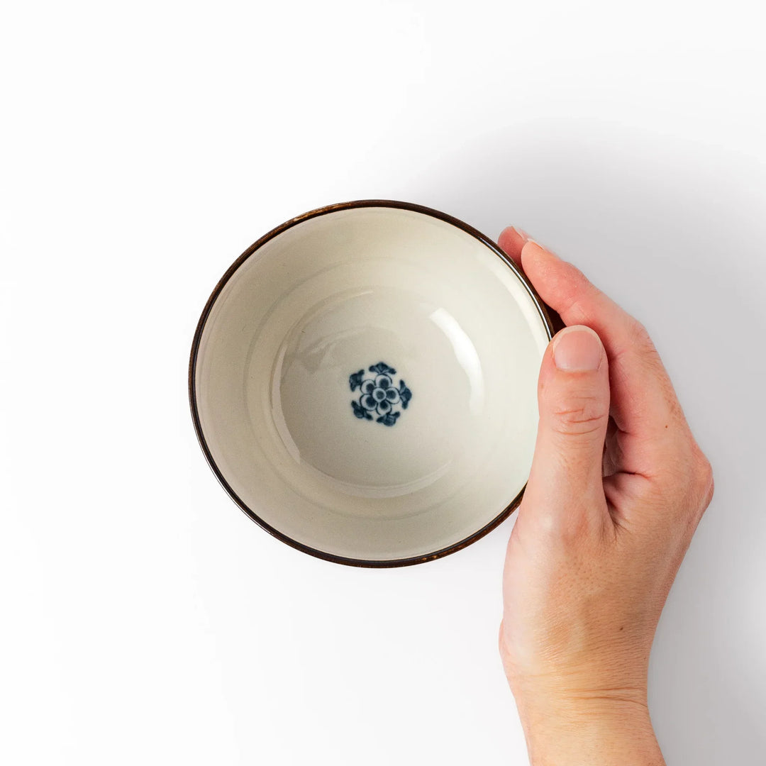 Traditional Japanese rice bowl with red green and gold motifs featuring waves florals and birds for refined meals.