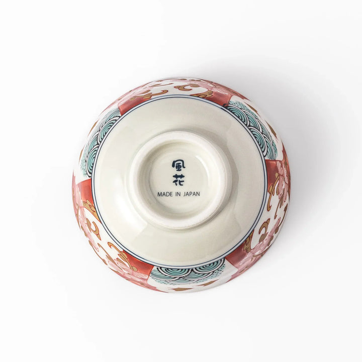 Traditional Japanese rice bowl with red green and gold motifs featuring waves florals and birds for refined meals.