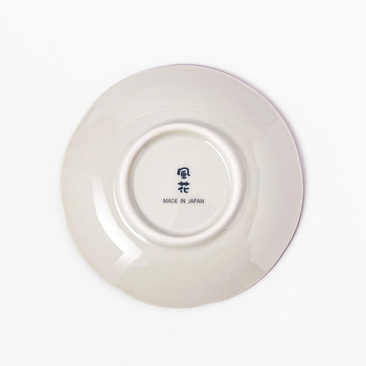 Scalloped sauce dish with red blue and green Japanese motifs and floral center for elegant dining.