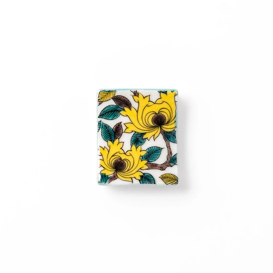 Japanese porcelain chopstick rest with yellow peony and teal leaf motif, hand-painted in traditional Kutani ware style.