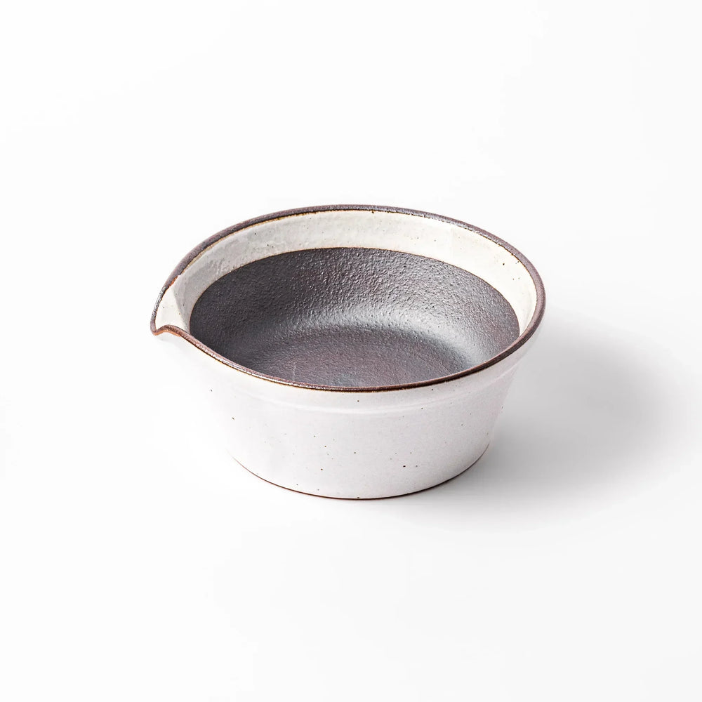 White ceramic suribachi mortar bowl with a smooth dark interior and spout, designed for effortless grinding and elegant table presentation.