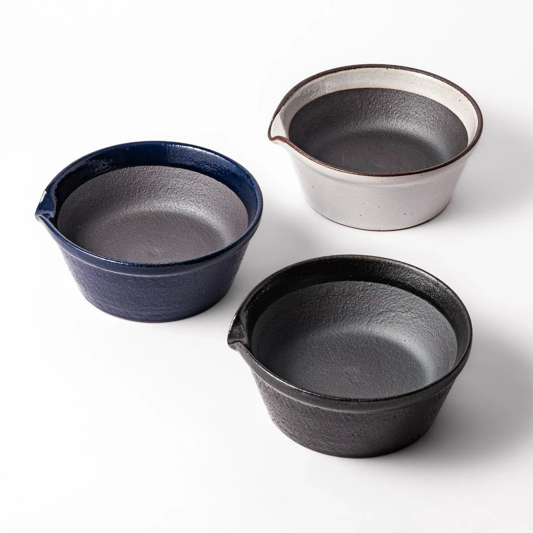 Set of three Japanese ceramic suribachi bowls in black blue and white with smooth interiors and spouts.
