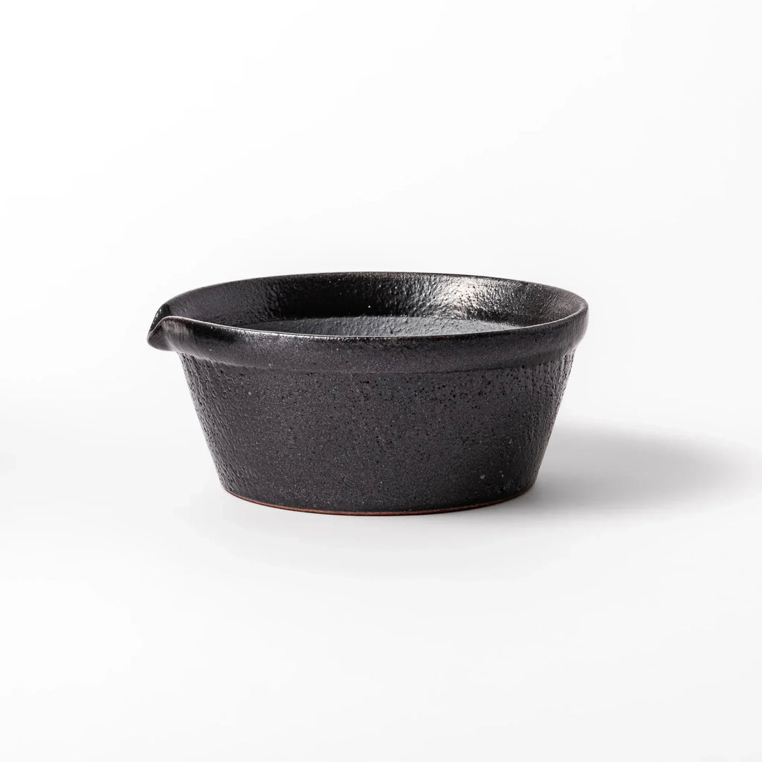 Black Japanese ceramic suribachi bowl with smooth interior and spout for grinding or mixing easy cleanup.