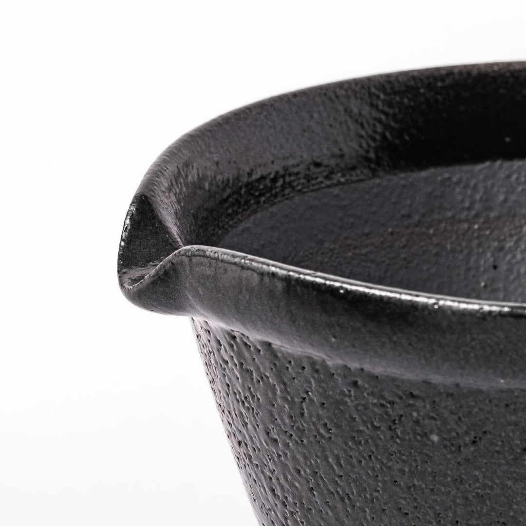 Black Japanese ceramic suribachi bowl with smooth interior and spout for grinding or mixing easy cleanup.