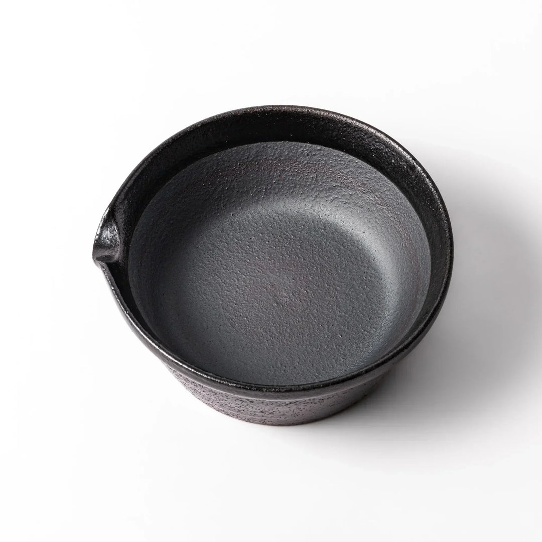 Black Japanese ceramic suribachi bowl with smooth interior and spout for grinding or mixing easy cleanup.
