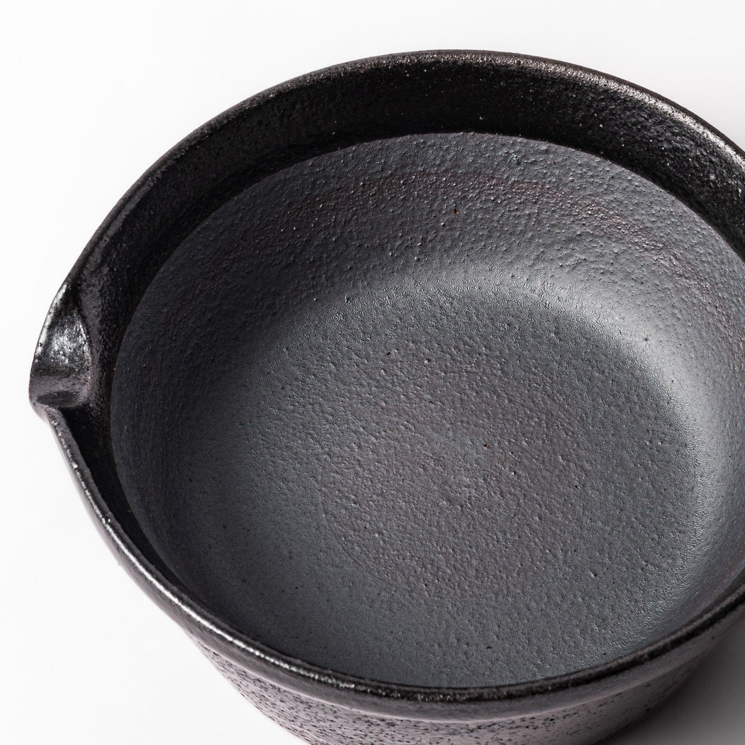 Black Japanese ceramic suribachi bowl with smooth interior and spout for grinding or mixing easy cleanup.