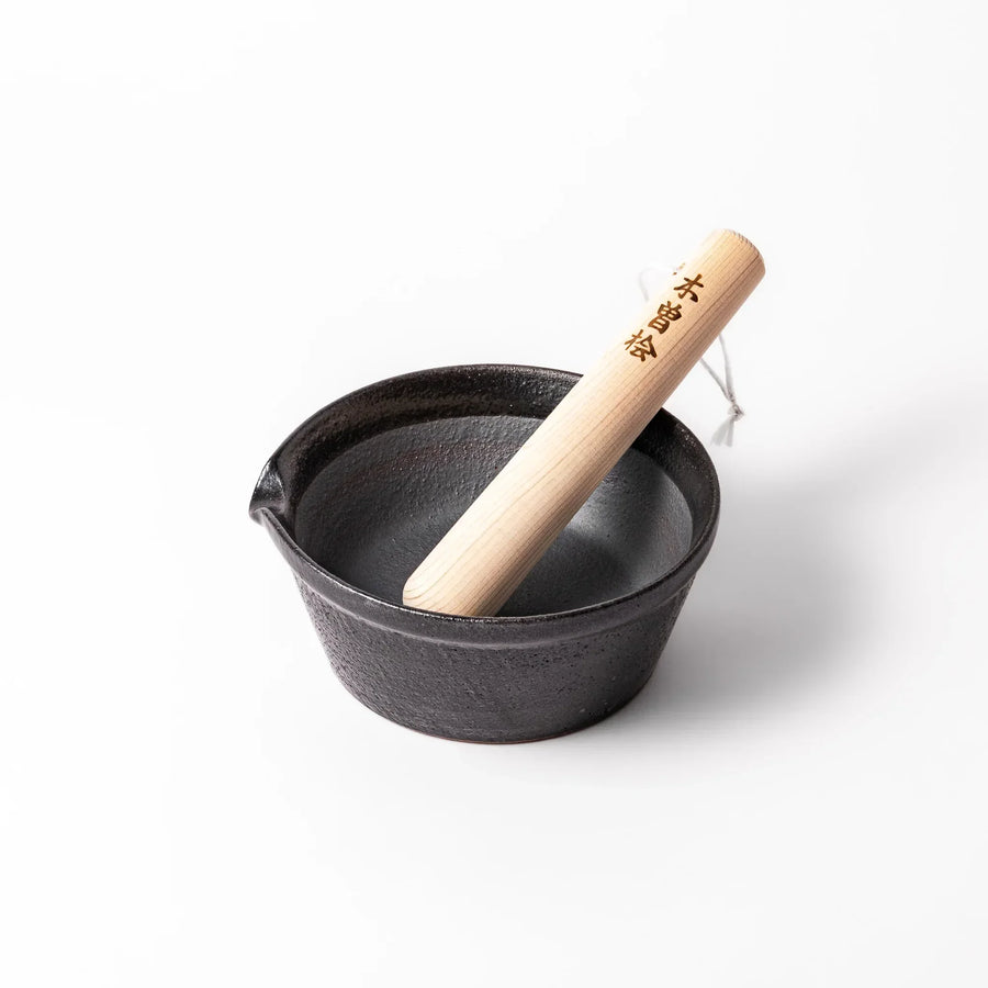 Black Japanese ceramic suribachi bowl with smooth interior and spout for grinding or mixing easy cleanup.