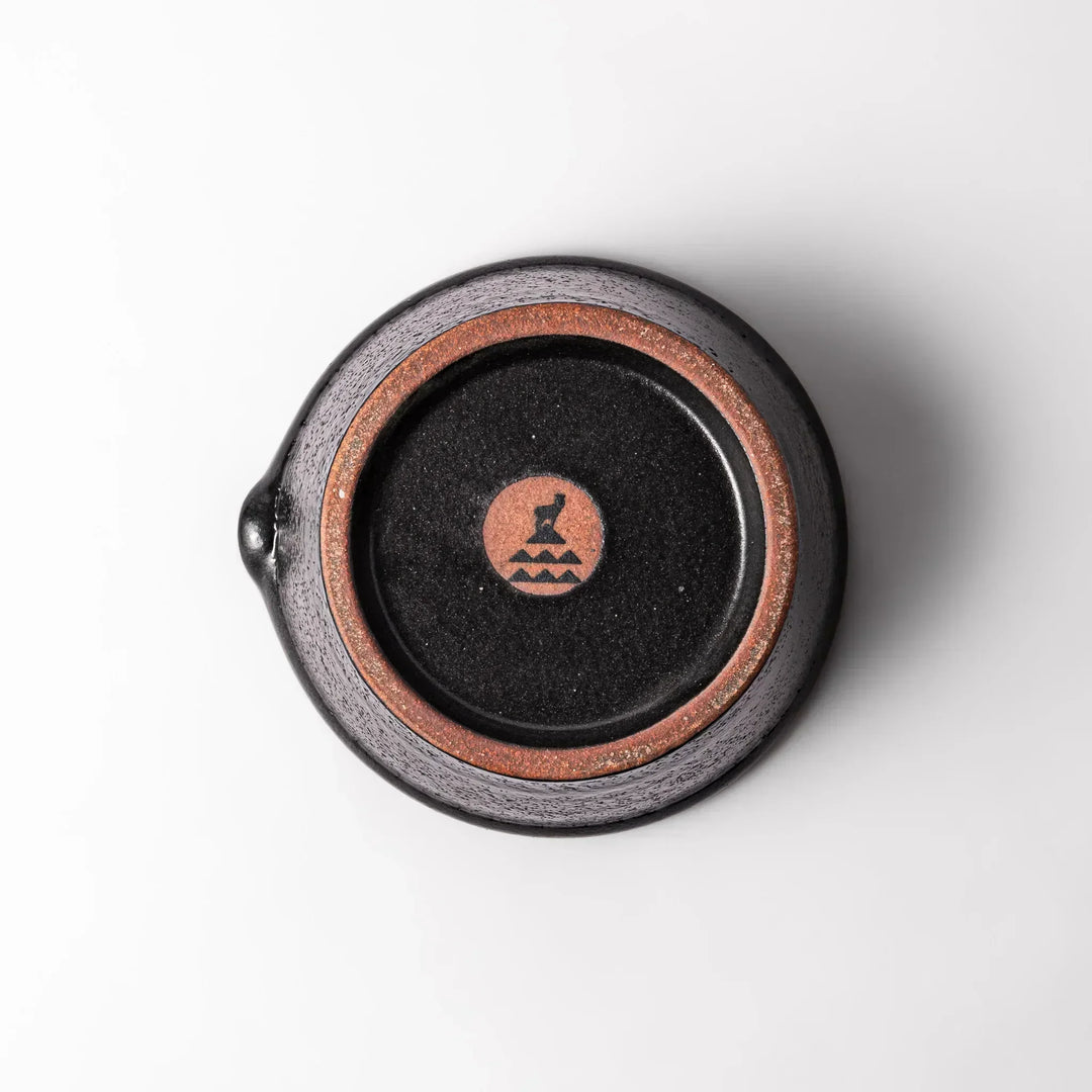 Black Japanese ceramic suribachi bowl with smooth interior and spout for grinding or mixing easy cleanup.