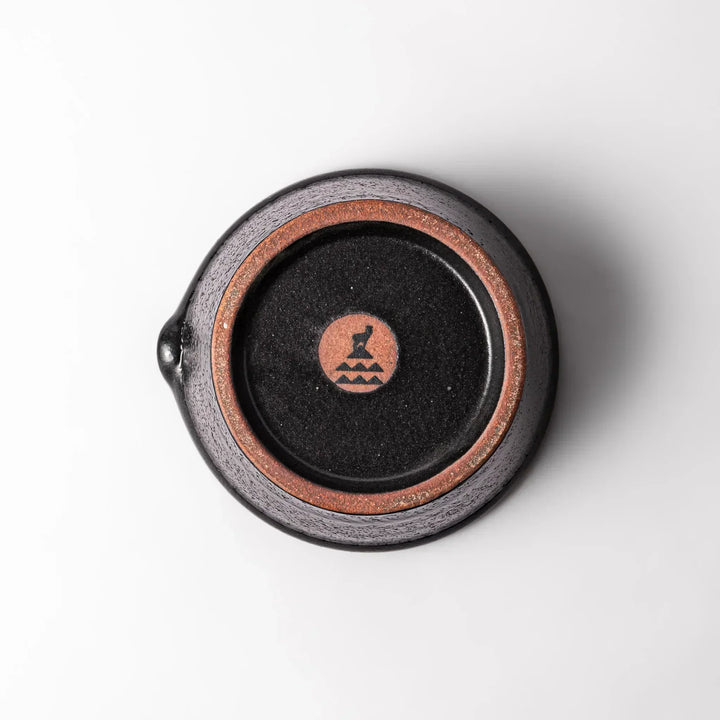 Black Japanese ceramic suribachi bowl with smooth interior and spout for grinding or mixing easy cleanup.