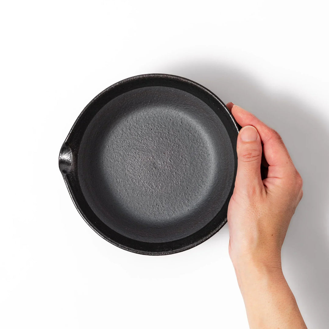 Black Japanese ceramic suribachi bowl with smooth interior and spout for grinding or mixing easy cleanup.