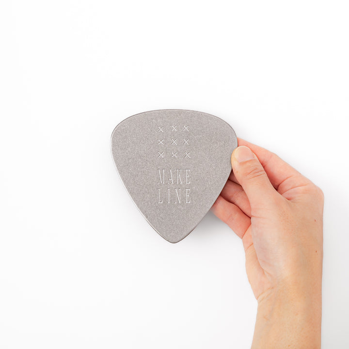 Unique guitar pick shaped metal coaster with vintage matte finish engraved with make line text and cross patterns