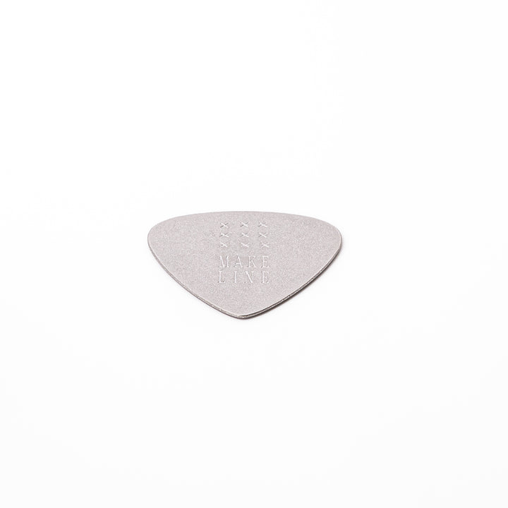Unique guitar pick shaped metal coaster with sandblasted textured finish engraved with make line text and cross patterns