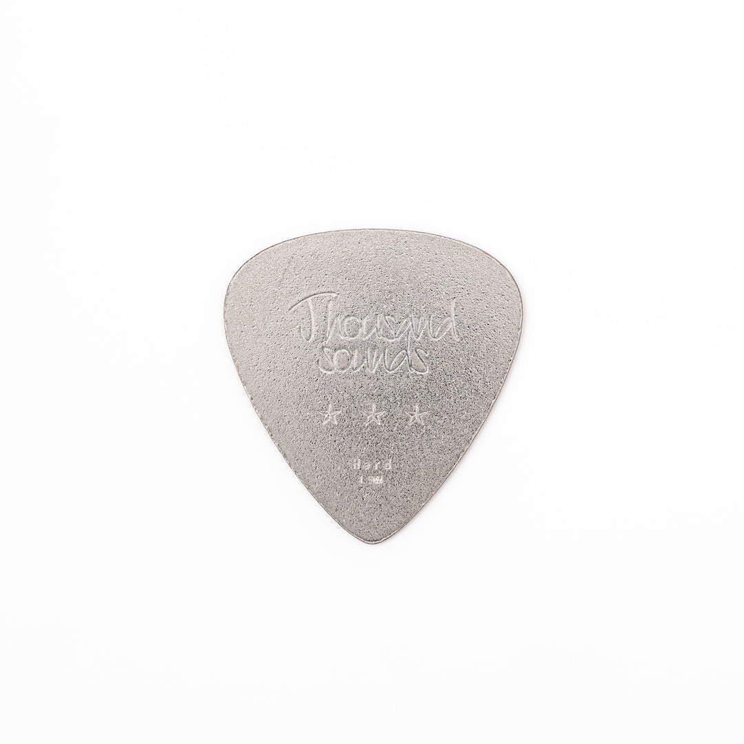 Unique guitar pick shaped metal coaster with sandblasted textured finish engraved with thousand sounds text and stars