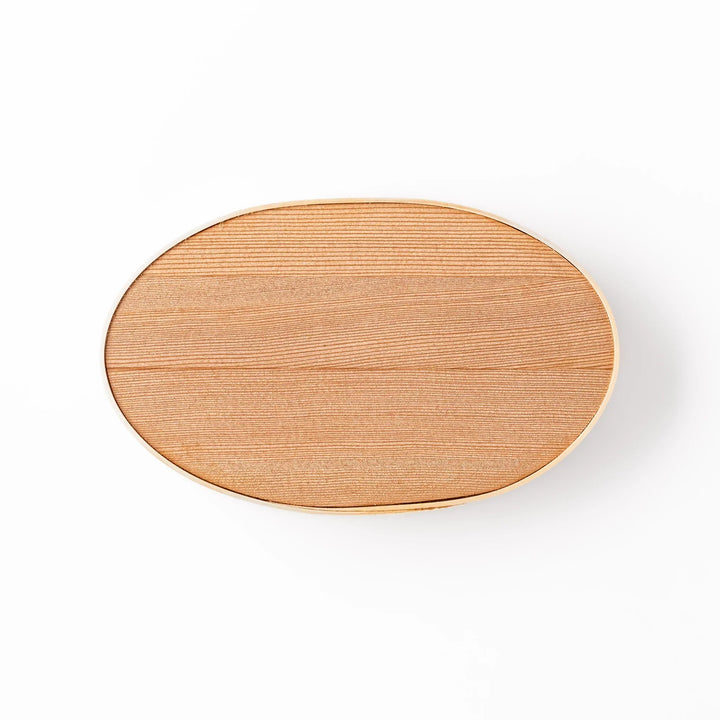 Oval Japanese hinoki wood bento box with traditional joinery for carrying light aromatic homemade meals.