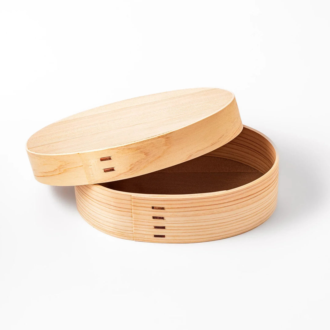 Oval Japanese hinoki wood bento box with traditional joinery for carrying light aromatic homemade meals.