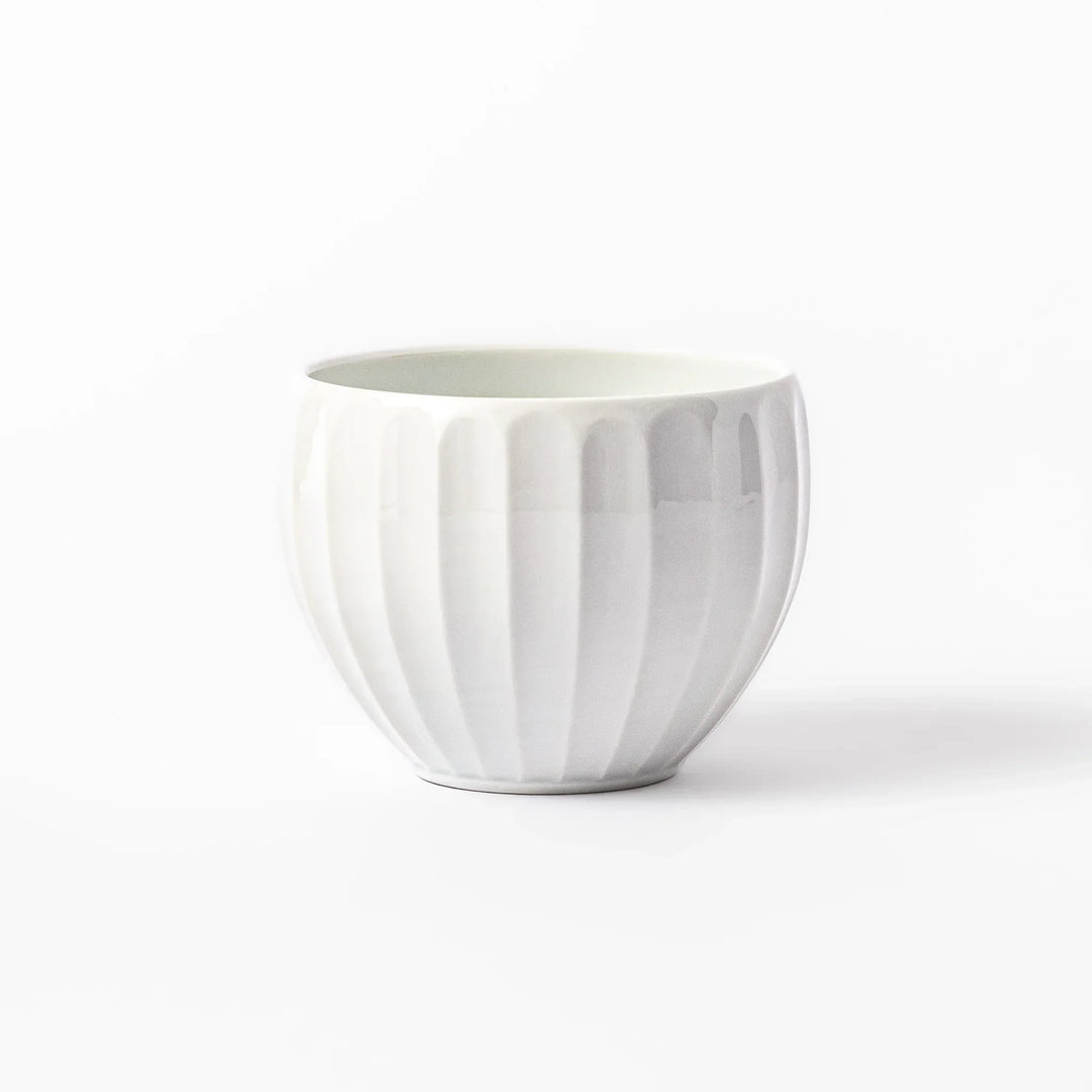 White teacup with vertical petal grooves and glossy finish perfect for serving hot tea in modern style.