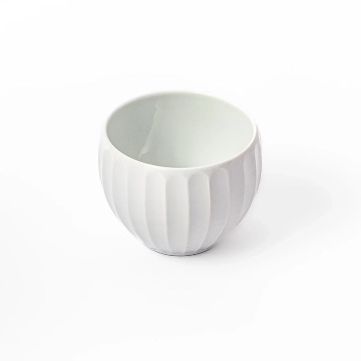 White teacup with vertical petal grooves and glossy finish perfect for serving hot tea in modern style.