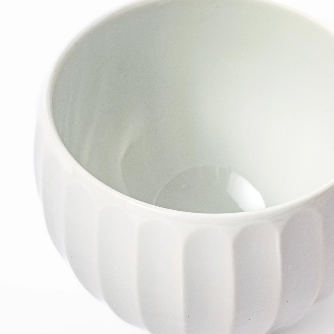White teacup with vertical petal grooves and glossy finish perfect for serving hot tea in modern style.