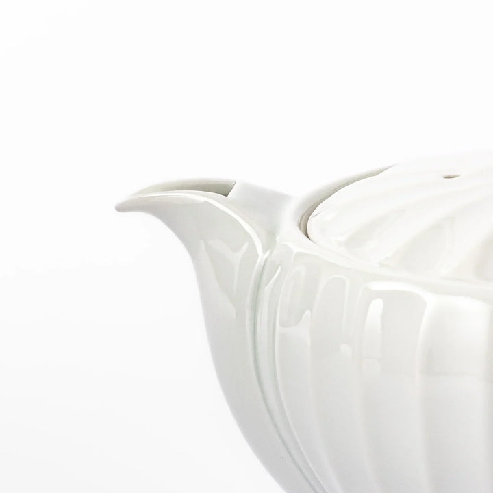White teapot with vertical petal-inspired ridges and a round lid, perfect for a refined and elegant tea presentation.