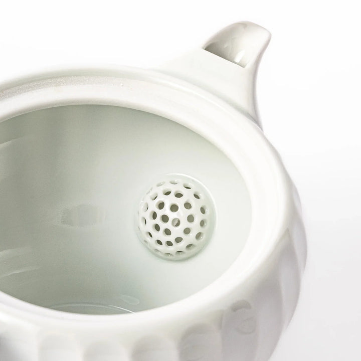 White teapot with vertical petal-inspired ridges and a round lid, perfect for a refined and elegant tea presentation.