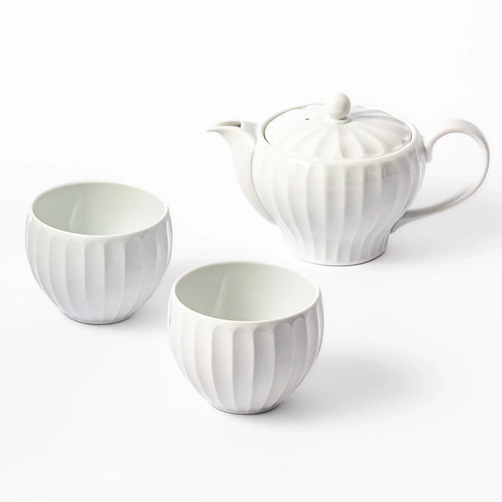 White teapot and two matching teacups with vertical petal-like ridges, arranged on a clean white background.