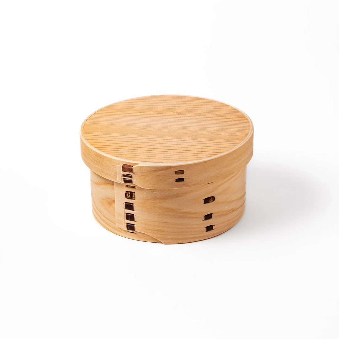Oval Japanese hinoki wood bento box with traditional joinery for carrying light aromatic homemade meals.