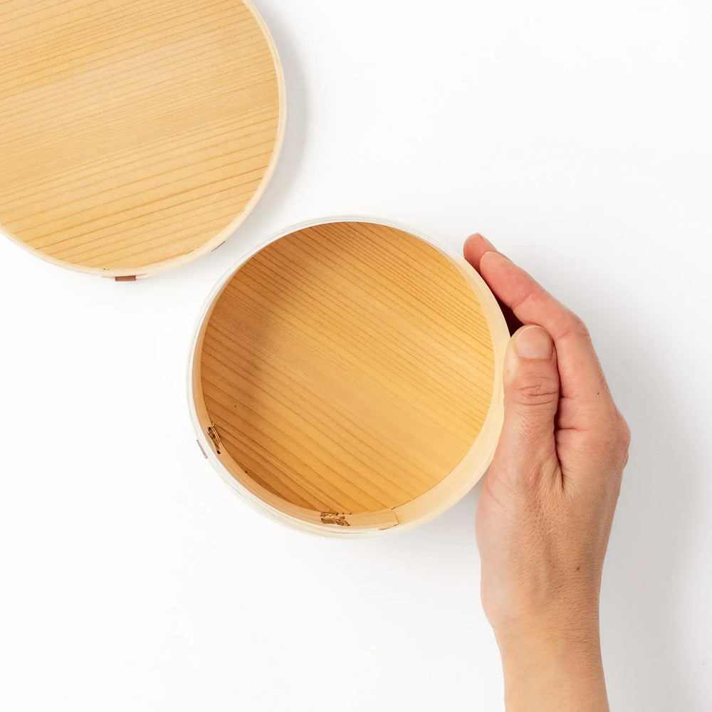 Oval Japanese hinoki wood bento box with traditional joinery for carrying light aromatic homemade meals.
