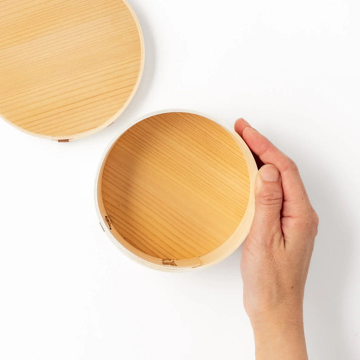 Oval Japanese hinoki wood bento box with traditional joinery for carrying light aromatic homemade meals.