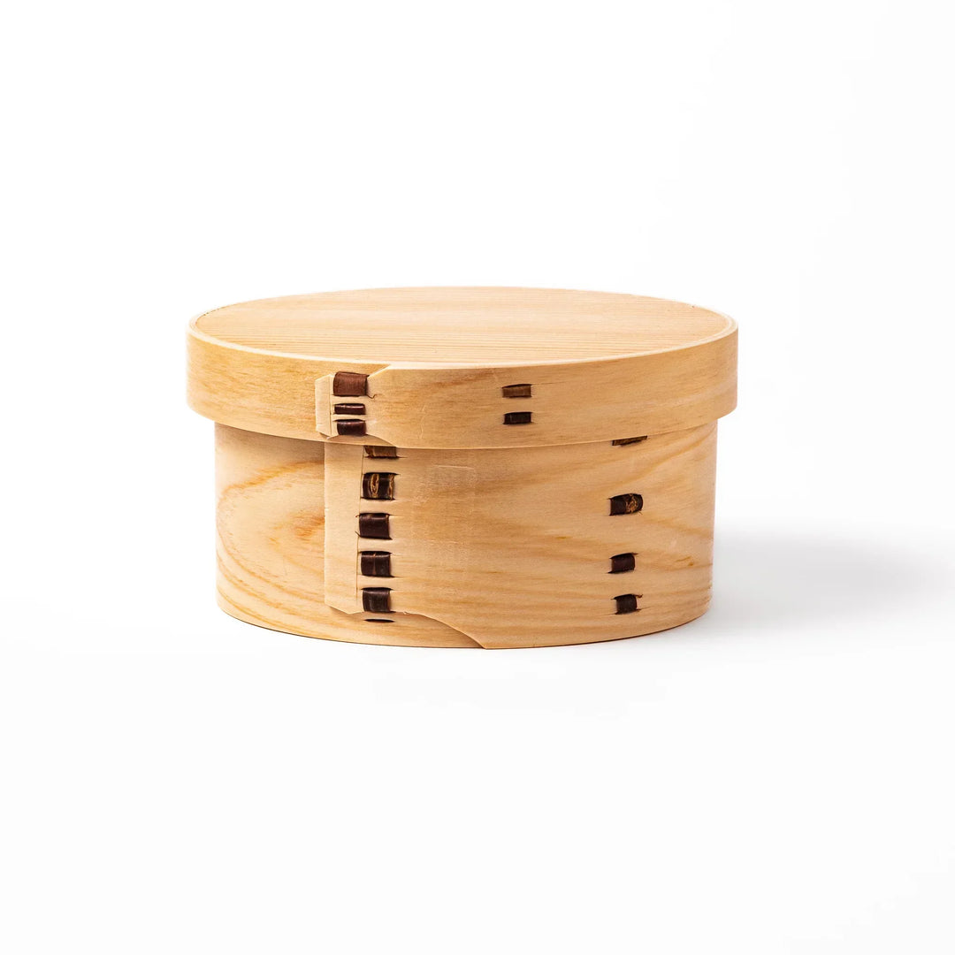 Oval Japanese hinoki wood bento box with traditional joinery for carrying light aromatic homemade meals.