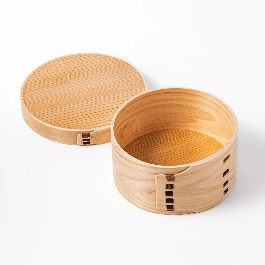 Oval Japanese hinoki wood bento box with traditional joinery for carrying light aromatic homemade meals.