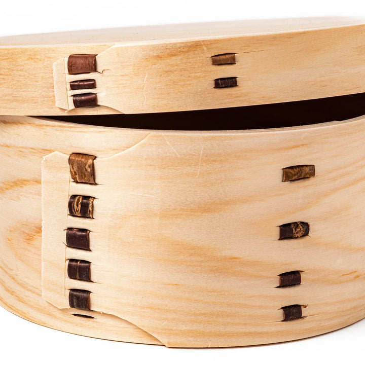 Oval Japanese hinoki wood bento box with traditional joinery for carrying light aromatic homemade meals.