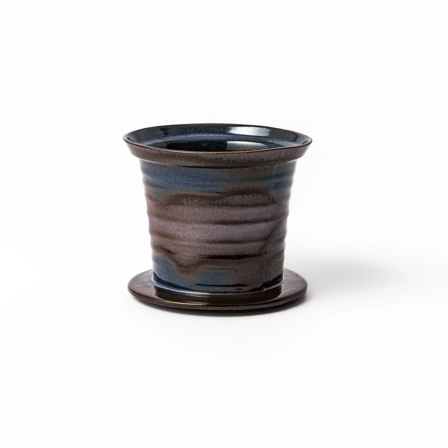 Handcrafted ceramic coffee dripper in brown and blue glaze with mesh filter for single serve brewing.
