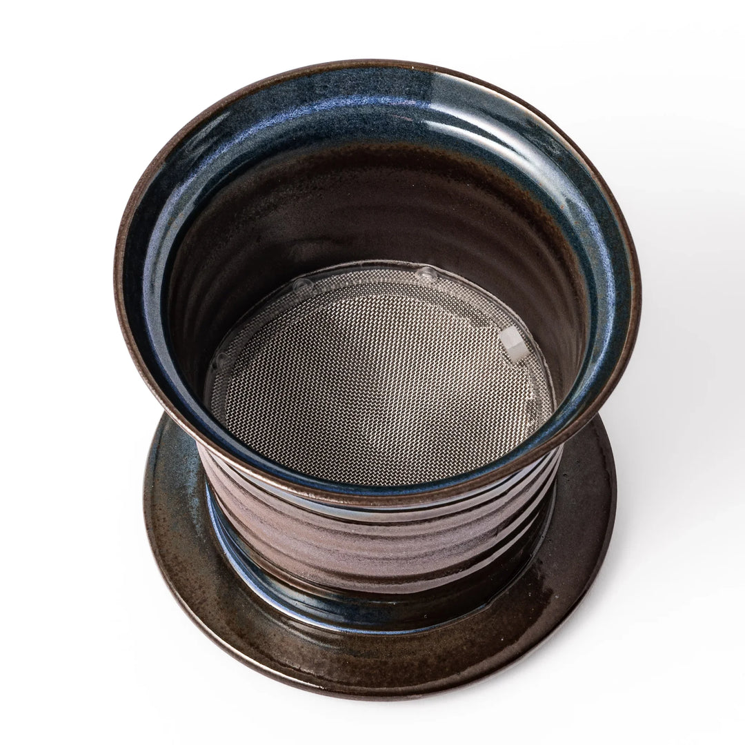 Handcrafted ceramic coffee dripper in brown and blue glaze with mesh filter for single serve brewing.