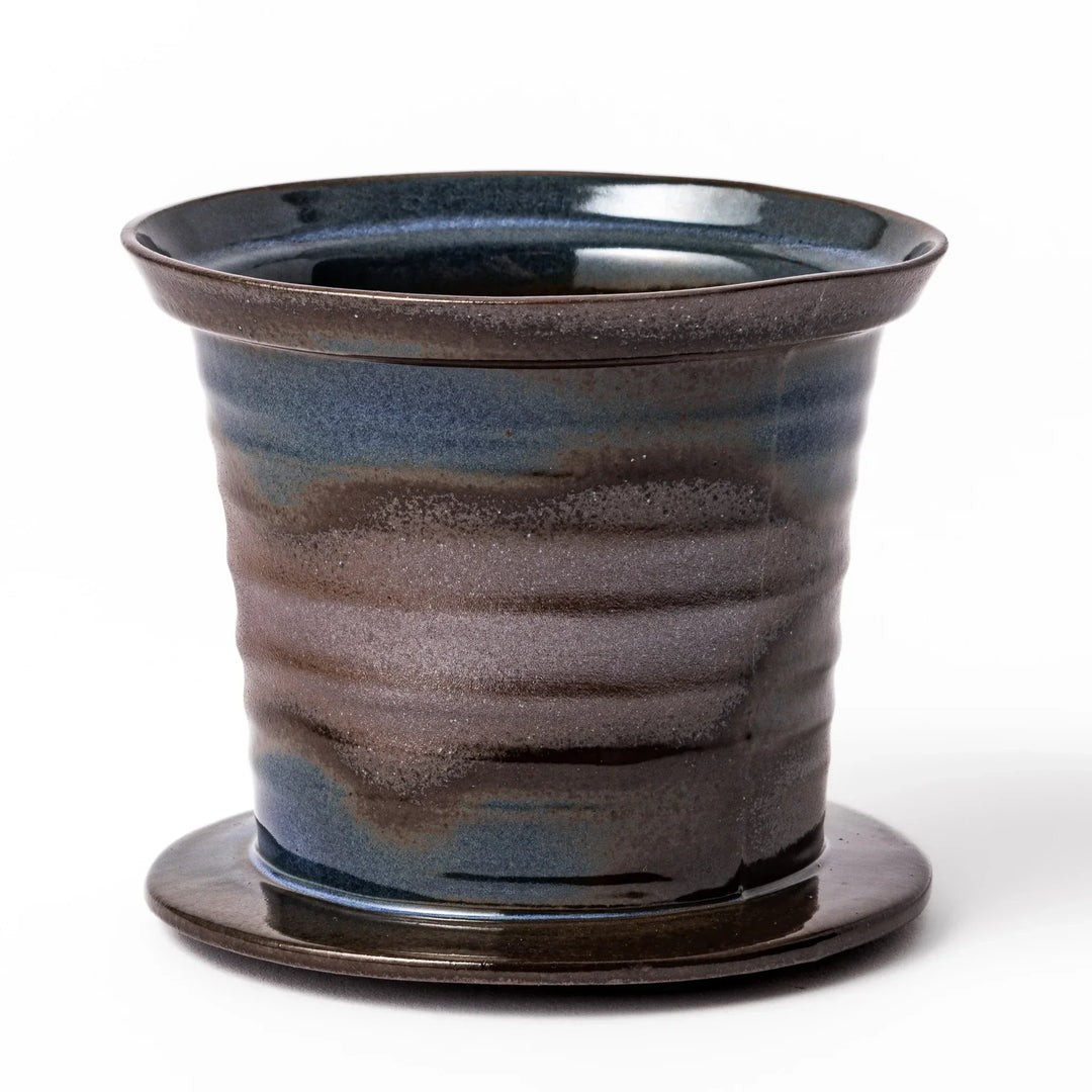 Handcrafted ceramic coffee dripper in brown and blue glaze with mesh filter for single serve brewing.