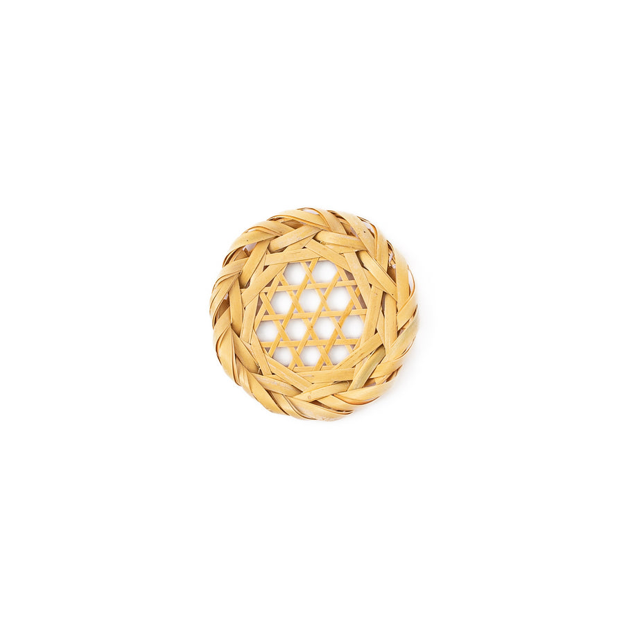 A round handwoven bamboo drink coaster showcasing a traditional star pattern weave and a braided natural fiber border