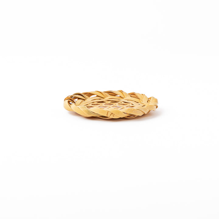 A round handwoven bamboo drink coaster showcasing a traditional star pattern weave and a braided natural fiber border