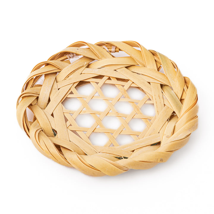 A round handwoven bamboo drink coaster showcasing a traditional star pattern weave and a braided natural fiber border