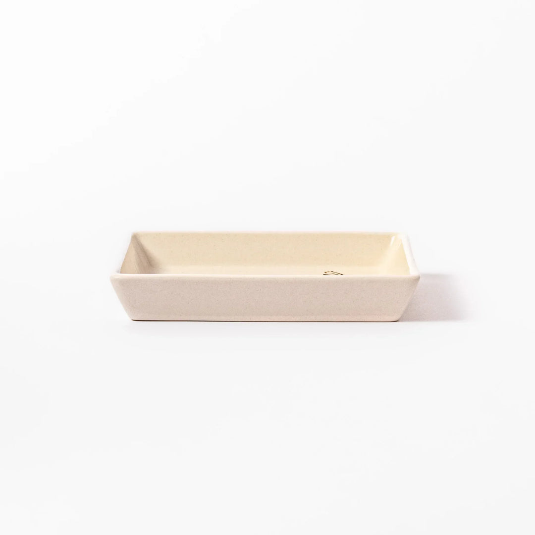 Beige square plate with playful calico cat and butterfly illustration, accented with dotted lines and paw prints.