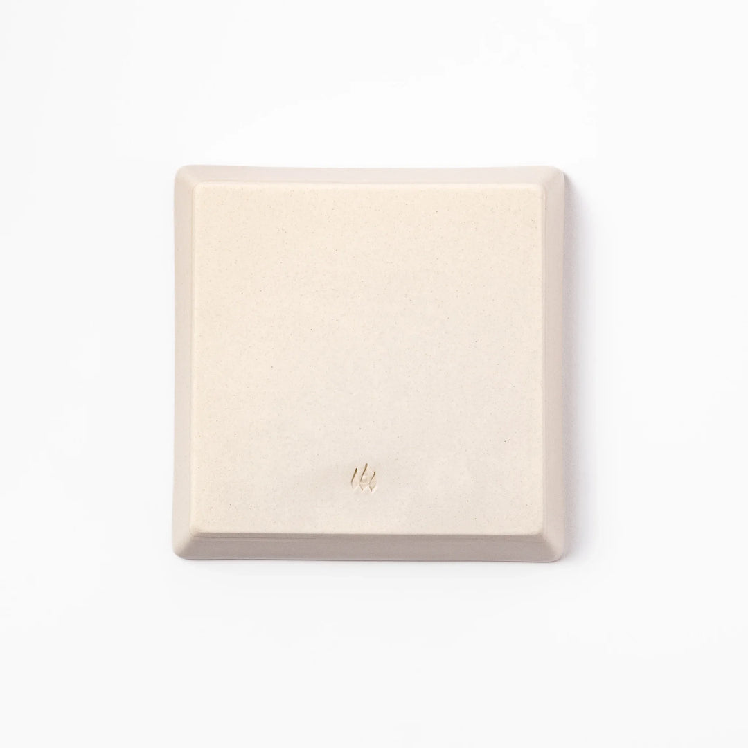 Beige square plate with playful calico cat and butterfly illustration, accented with dotted lines and paw prints.